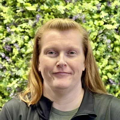 Kathy Wade smiling in front of greenery