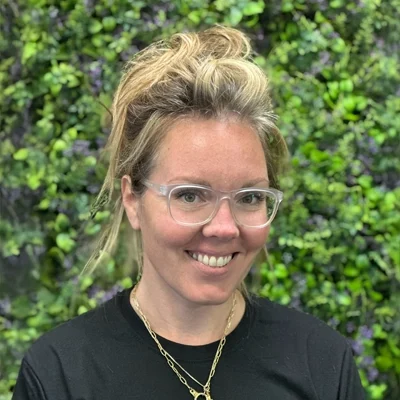 Kim Badalamenti smiling in front of greenery