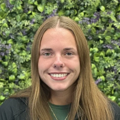 Lauren Davis smiling in front of greenery